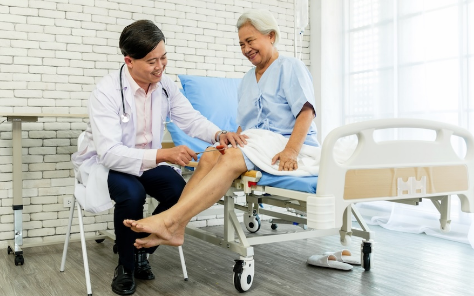 doctor performs a reflex test on an elderly woman's knee